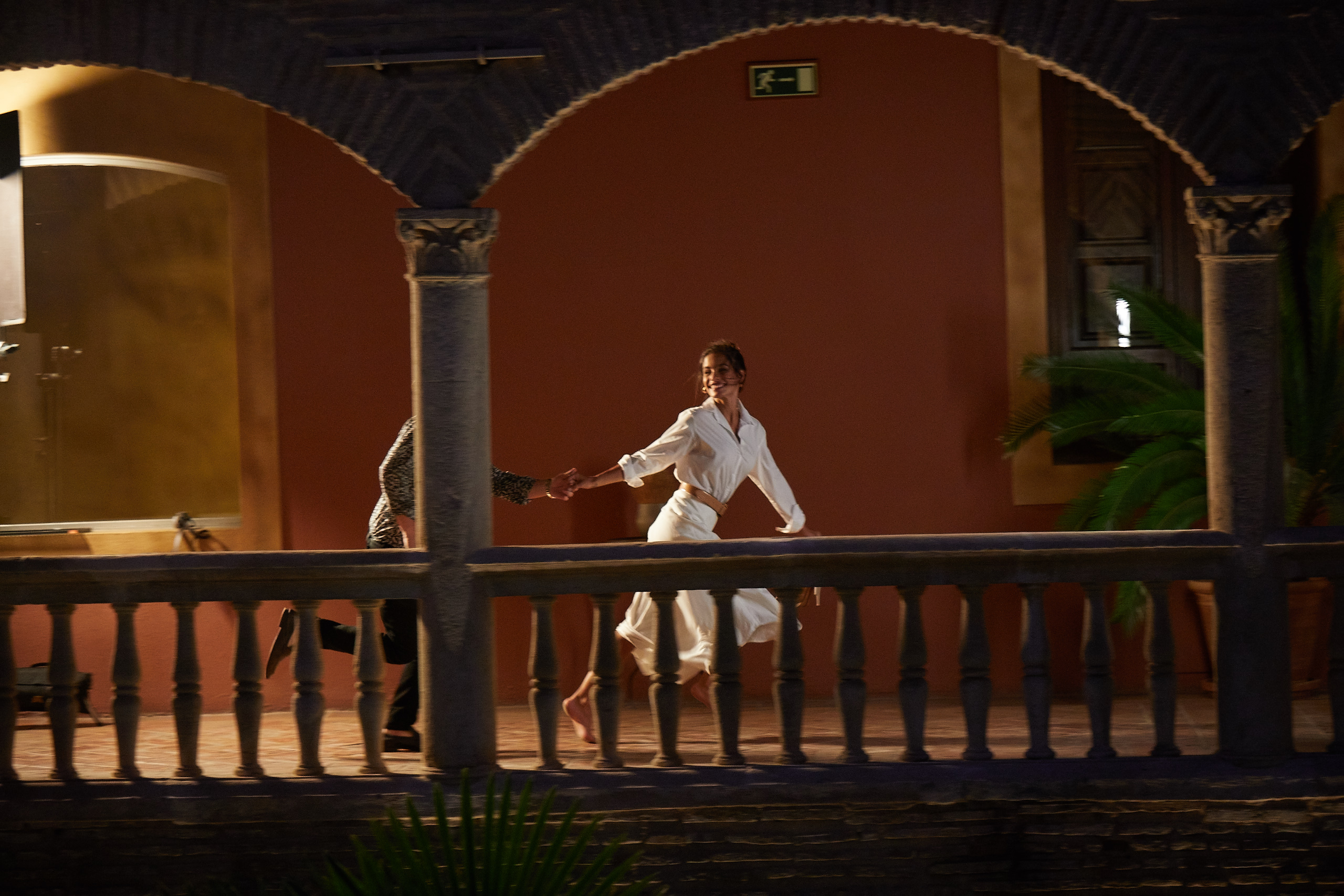 A playful couple running through an ancient courtyard